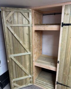 Wooden storage cabinet with a rustic design, featuring two open shelves and double doors. Ideal for organizing items in a home or workshop.