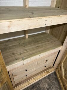 Wooden furniture piece featuring a spacious top shelf and two drawers, showcasing a natural finish and sturdy construction, ideal for storage and organization in any room.